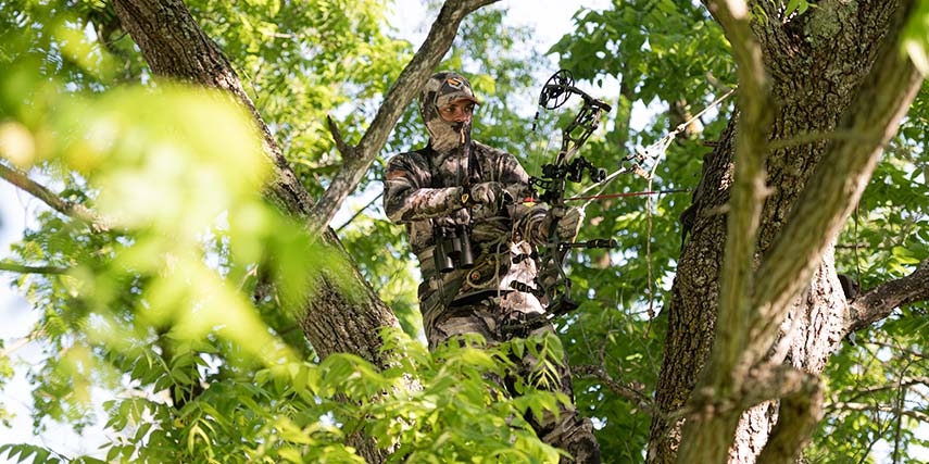 man standing in tree stand waiting for deer