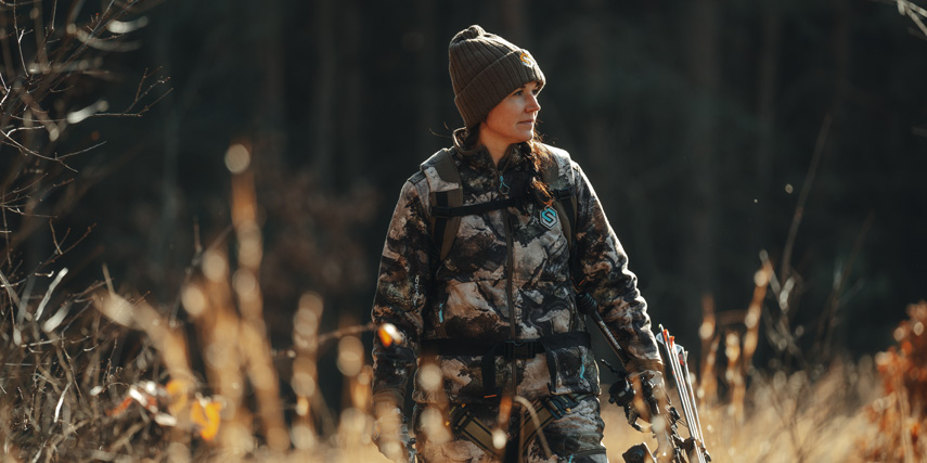 Female hunter walking in woods 